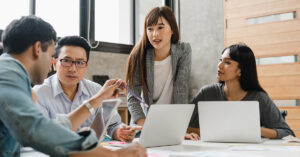 diverse coworkers working together in boardroom, brainstorming, discussing and analyzing and planning business strategy.