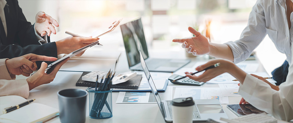 diverse coworkers working together in boardroom, brainstorming, discussing and analyzing and planning business strategy.